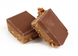 A layer of freshly roasted and salted pecan pieces, topped with our own soft and buttery caramel with creamy milk chocolate spread over the top.